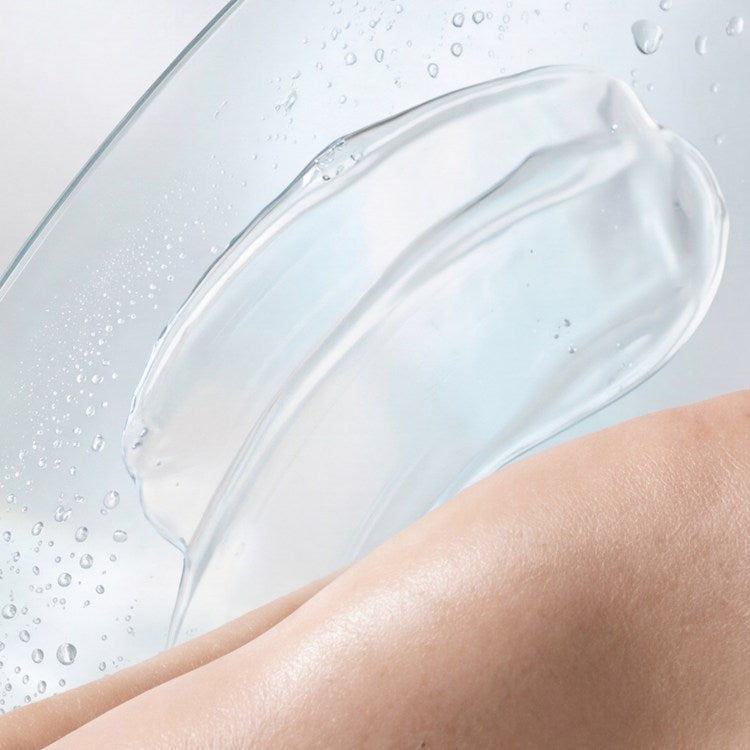 A clear gel drawn across wet glass beside skin.